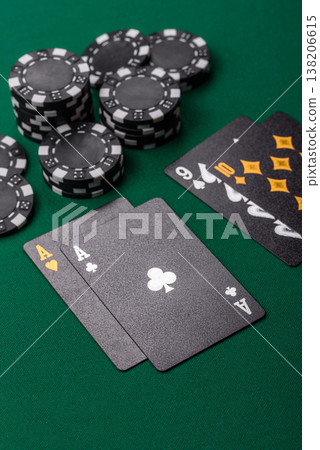Playing cards and chips on a green cloth, a gambling game of blackjack or baccarat. Cards and chips 138206615