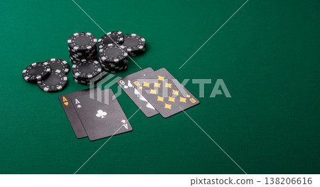 Playing cards and chips on a green cloth, a gambling game of blackjack or baccarat. Cards and chips Playing cards and chips on a green cloth, a gambling game of blackjack or baccarat. Cards and chips 138206616