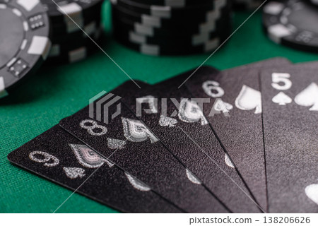 Playing cards and chips on a green cloth, a gambling game of poker. Cards and chips 138206626