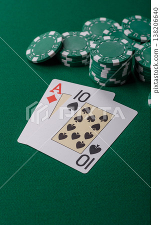 Playing cards and chips on a green cloth, a gambling game of blackjack or baccarat. Cards and chips Playing cards and chips on a green cloth, a gambling game of blackjack or baccarat. Cards and chips 138206640