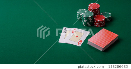 Playing cards and chips on a green cloth, a gambling game of blackjack or baccarat. Cards and chips Playing cards and chips on a green cloth, a gambling game of blackjack or baccarat. Cards and chips 138206683