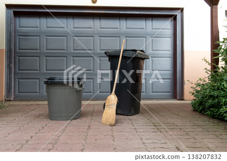 two trash cans in front of the garage door. cleaning supplies, two trash cans in front of the garage door. cleaning supplies, 138207832