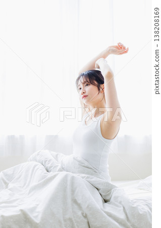 清晨，一位年輕女子在臥室裡伸懶腰。 138208169