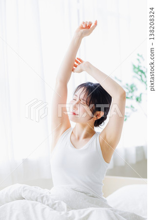 清晨，一位年輕女子在臥室裡伸懶腰。 138208324