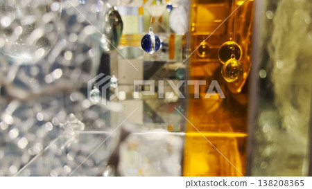 Abstract glass installation with suspended spheres and mirrored surfaces. Light reflections and refractions create layered shapes, depth, and a surreal geometric composition Abstract glass installation with suspended spheres and mirrored surfaces. Light reflections and refractions create layered shapes, depth, and a surreal geometric composition 138208365
