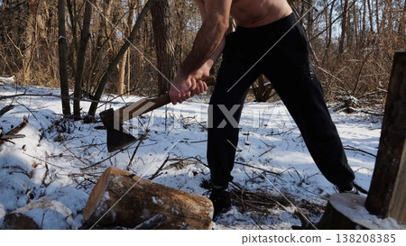 Shirtless young man chopping firewood in a sunny winter forest. Muscular guy working with axe in snowy woodland. Concept of strength, masculine, energy and harmony with nature during cold season Shirtless young man chopping firewood in a sunny winter forest. Muscular guy working with axe in snowy woodland. Concept of strength, masculine, energy and harmony with nature during cold season 138208385