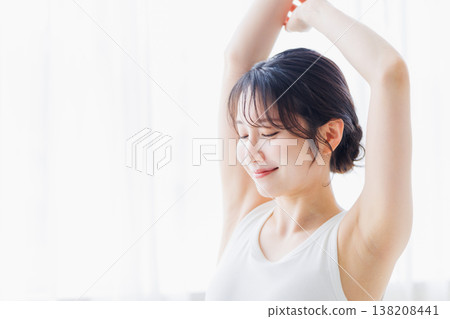 清晨，一位年輕女子在臥室裡伸懶腰。 138208441