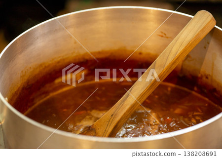 用木匙攪拌湯。 138208691