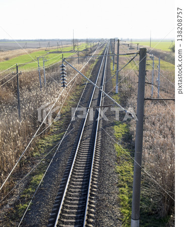 Plot railway. Top view on the rails. High-voltage power lines for electric trains Plot railway. Top view on the rails. High-voltage power lines for electric trains 138208757
