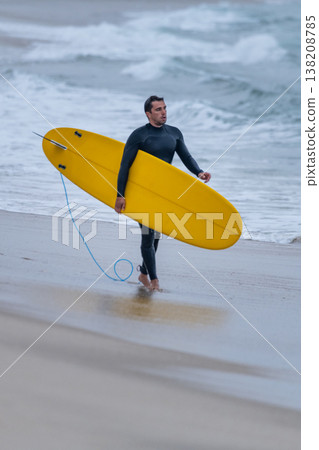 Surfer with board under his arm Surfer with board under his arm 138208785