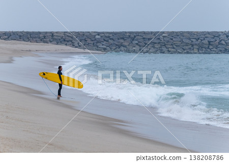 Surfer with board under his arm Surfer with board under his arm 138208786