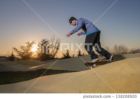 Skateboarder on a pump track park Skateboarder on a pump track park 138208920