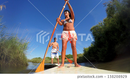 Woman stand up paddleboarding Woman stand up paddleboarding 138208929