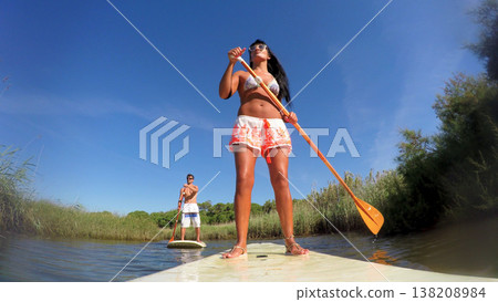Woman stand up paddleboarding 138208984