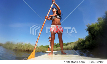Woman stand up paddleboarding 138208985