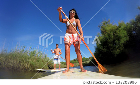 Woman stand up paddleboarding Woman stand up paddleboarding 138208990