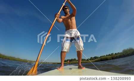 Man stand up paddleboarding Man stand up paddleboarding 138208993