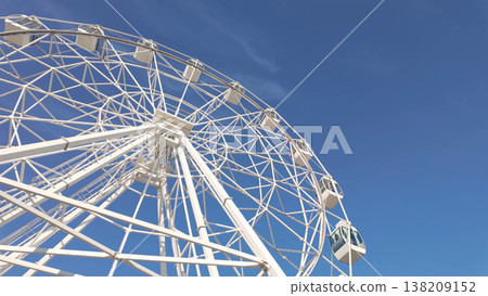 White ferris wheel against a clear blue sky White ferris wheel against a clear blue sky 138209152