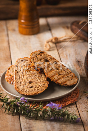 Toasted Sourdough Bread Slices on a Gray Plate with Rosemary Toasted Sourdough Bread Slices on a Gray Plate with Rosemary 138209301