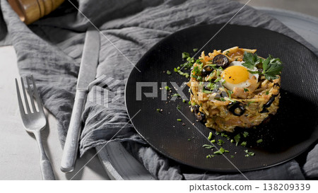 Gourmet Plated Bacalhau a Bras with Fried Egg and Black Olives on a Dark Ceramic Plate Gourmet Plated Bacalhau a Bras with Fried Egg and Black Olives on a Dark Ceramic Plate 138209339