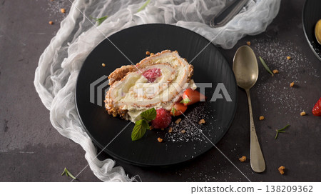 Slice of Berry Meringue Roulade with Fresh Raspberries and Mint 138209362
