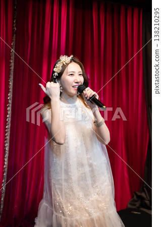 一位年輕女子在舞台上唱卡拉OK 138210295