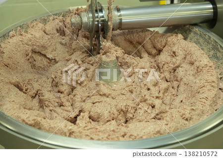 A scene of ground meat being produced using a commercial meat grinder. Meat processing plant. Image of the manufacturing process for mixed ground meat. A scene of ground meat being produced using a commercial meat grinder. Meat processing plant. Image of the manufacturing process for mixed ground meat. 138210572