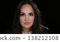 Empowerment and Confidence Portrait of a Young Woman with Dark Hair and Eyes Against a Dark 138212108