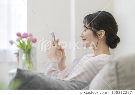 操作智能手機的年輕女子的簡介 138212237
