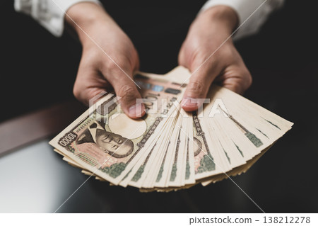 Hand holding money 138212278