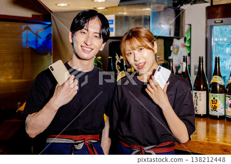 Part-time job at an izakaya (Japanese pub) using a smartphone. Part-time job at an izakaya (Japanese pub) using a smartphone. 138212448