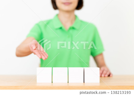 A middle-aged care worker wearing a green polo shirt and Block 138213193
