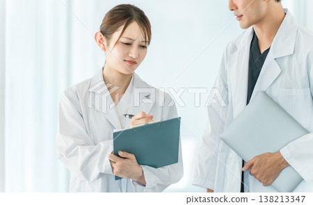 Doctors, physicians, medical professionals, pharmacists, scientists, and researchers (men and women) conversing in a hospital corridor. Doctors, physicians, medical professionals, pharmacists, scientists, and researchers (men and women) conversing in a hospital corridor. 138213347