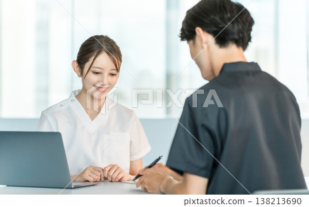 A nurse in a nurse's uniform and a female counselor are seen talking to a male patient. A nurse in a nurse's uniform and a female counselor are seen talking to a male patient. 138213690