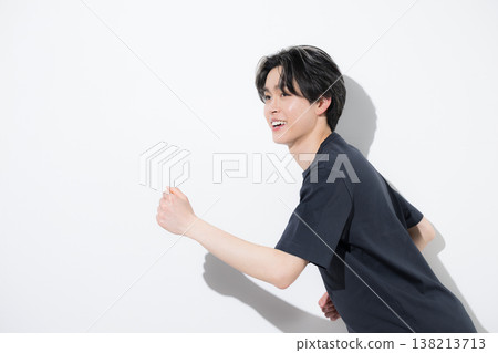 An image of a refreshing young man in a running pose, showing his running profile, suggesting strength training or exercise. 138213713