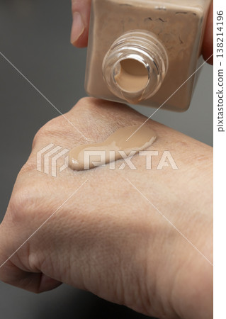 A woman's hands applying makeup; liquid foundation. A woman's hands applying makeup; liquid foundation. 138214196