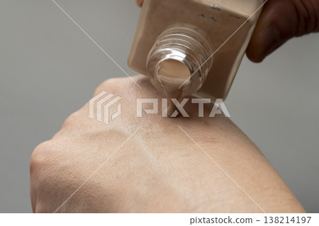 A woman's hands applying makeup; liquid foundation. A woman's hands applying makeup; liquid foundation. 138214197
