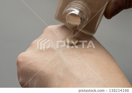 A woman's hands applying makeup; liquid foundation. A woman's hands applying makeup; liquid foundation. 138214198
