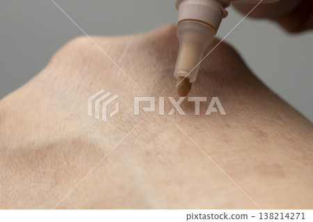 A woman's hands applying makeup; hands applying cream foundation. A woman's hands applying makeup; hands applying cream foundation. 138214271