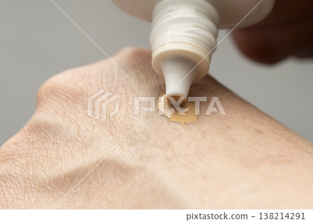 A woman's hands applying makeup; hands applying sunscreen. A woman's hands applying makeup; hands applying sunscreen. 138214291