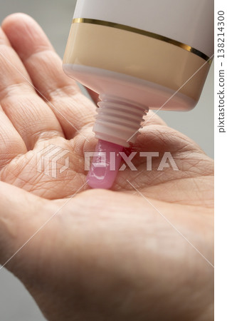 A woman's hands applying makeup; hands applying makeup; facial cleanser. A woman's hands applying makeup; hands applying makeup; facial cleanser. 138214300