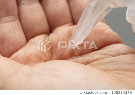 A woman's hands applying makeup; hands applying makeup; cleansing oil. A woman's hands applying makeup; hands applying makeup; cleansing oil. 138214379