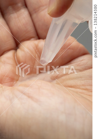 A woman's hands applying makeup; hands applying makeup; cleansing oil. A woman's hands applying makeup; hands applying makeup; cleansing oil. 138214380