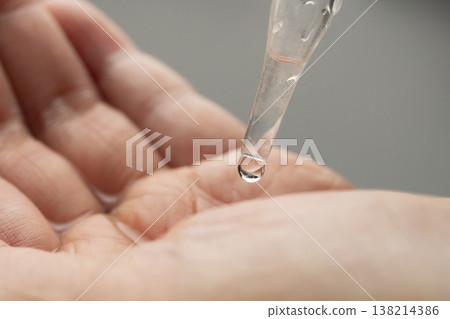 A woman's hands applying makeup; her hands applying makeup; beauty serum. A woman's hands applying makeup; her hands applying makeup; beauty serum. 138214386