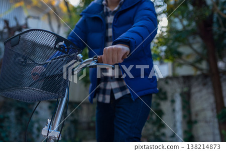 Wearing a blue down jacket while riding a bicycle 138214873