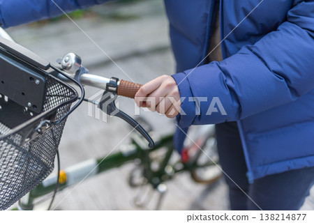 Wearing a blue down jacket while riding a bicycle 138214877