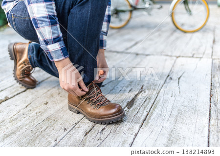 A man ties his boot laces 138214893