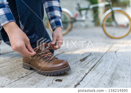 Tying hiking boot laces 138214895