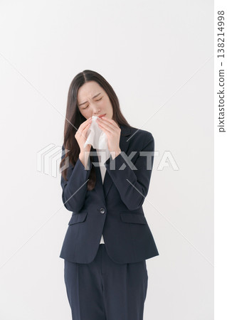 一位患有花粉症的女商人擤了擤鼻子。 138214998