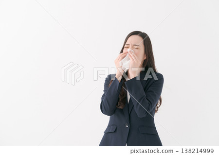 一位患有花粉症的女商人擤了擤鼻子。 138214999